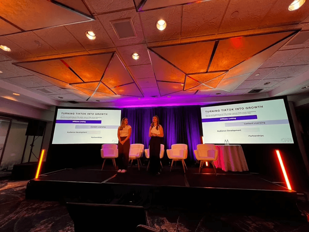 Two presenters on stage beside screens reading “Turning TikTok into growth”