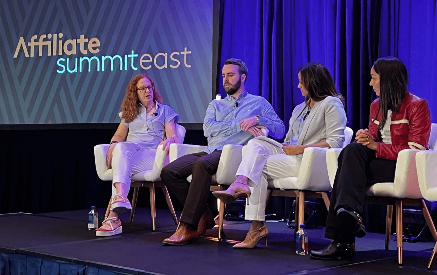 Four panelists seated on stage at Affiliate Summit East